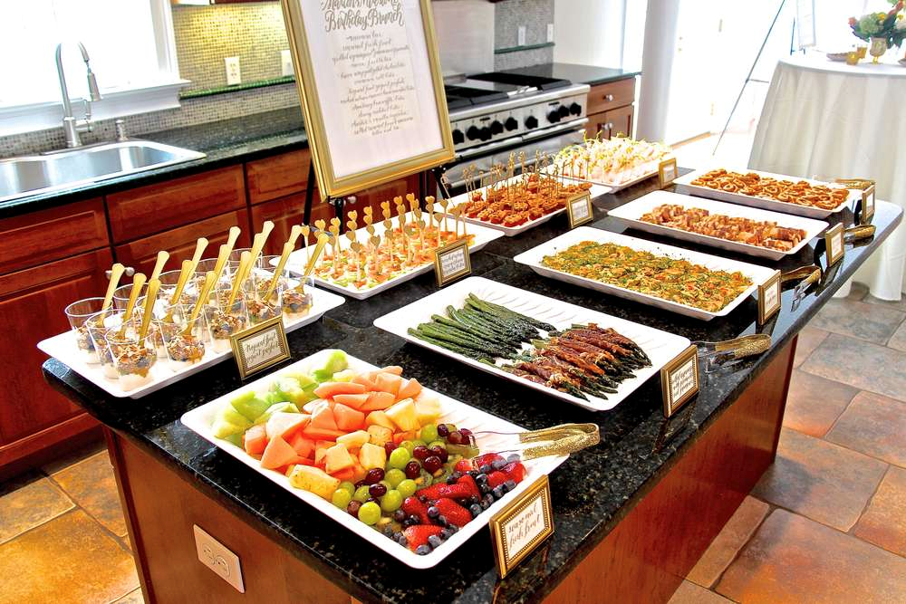 several-trays-of-food-sitting-on-top-of-a-kitchen-counter